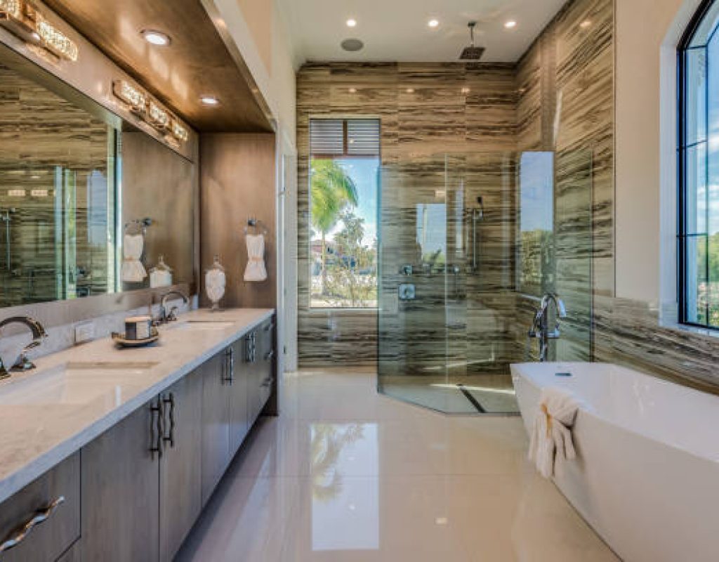 Tile installer fitting large porcelain slab in an upscale Fitchburg, WI master bathroom renovation