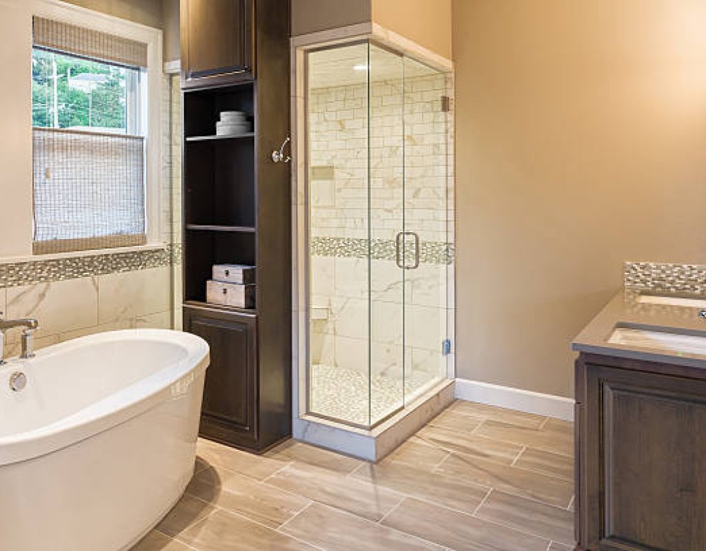 Homeowner reviewing new walk-in shower and vanity installation during bathroom remodel in Waunakee home